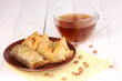 Sweet baklava on plate with tea on wooden background