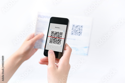 Photo: Woman scanning QR code in the magazine Woman scanning QR code in the magazine