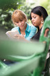 Foto: college students studying on textbook in park college students studying on textbook in park