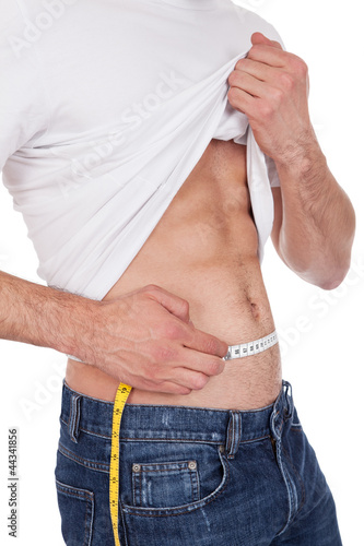 Photo: Muscular man measuring waist Muscular man measuring waist