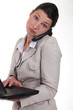woman standing with phone and laptop