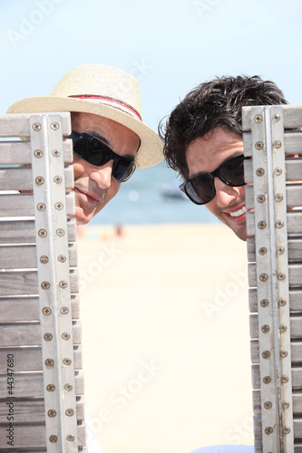 Photo: senior and young man relaxing on beach senior and young man relaxing on beach