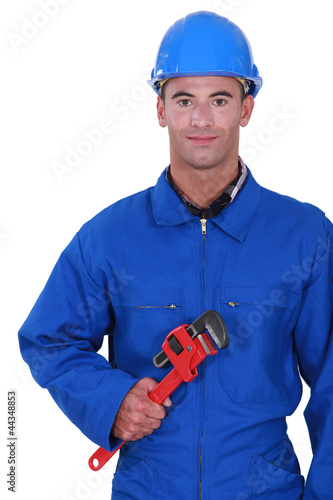 Photo: Worker holding red wrench Worker holding red wrench