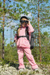 Little girl in a forest looking through binoculars