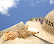 beach hat and shells on sand with blue sky