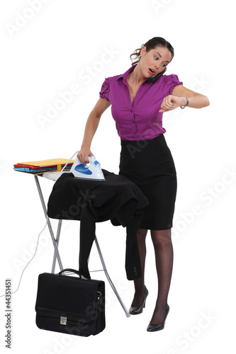 Photo: businesswoman in a hurry ironing her suit businesswoman in a hurry ironing her suit