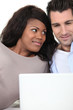 Couple at home looking at laptop