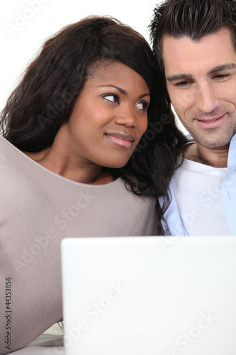 Photo: Couple at home looking at laptop Couple at home looking at laptop
