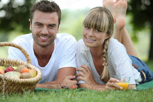 Photo: Couple having romantic picnic in a field Couple having romantic picnic in a field