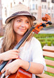 Woman with cello on the bench in square