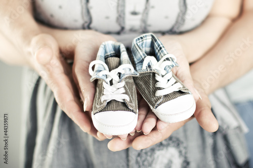 Photo: Newborn baby booties in parents hands Newborn baby booties in parents hands