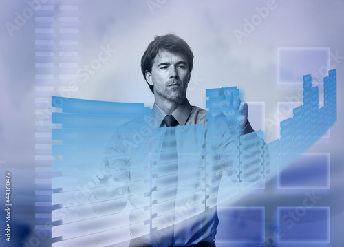 Photo: Businessman touching a holographic screen. Businessman touching a holographic screen.