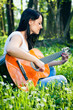 Young woman playing the guitar outdoors