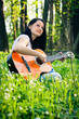 Young woman playing the guitar outdoors