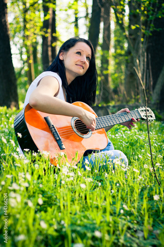 Photo: Young woman playing the guitar outdoors Young woman playing the guitar outdoors