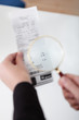 Businesswoman looking at check trough the loupe