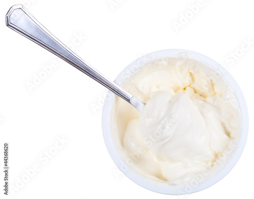Photo: metal spoon in tub of sour cream metal spoon in tub of sour cream