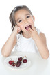 Little girl eating red fruit