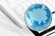 Photo: Glass globe and pen on finance Glass globe and pen on finance