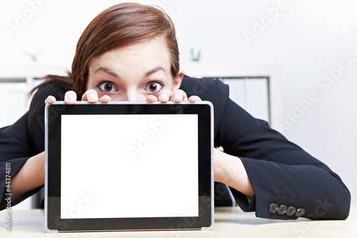 Photo: Frau schaut erstaunt über Tablet Computer Frau schaut erstaunt über Tablet Computer