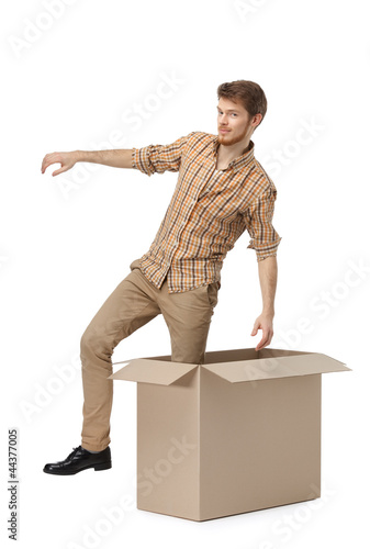 Photo: Young man gets out of the cardboard Young man gets out of the cardboard