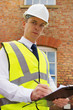 Construction professional with clipboard, an inspector, surveyor