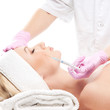 Foto: Portrait of a young woman laying on a botox injection procedure Portrait of a young woman laying on a botox injection procedure