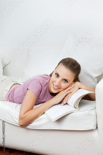 Foto: Woman Lying On Sofa With Book Woman Lying On Sofa With Book