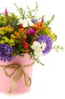 Bouquet of flowers and fruit in pink bucket.