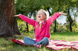 happy little girl with hands up in summer park