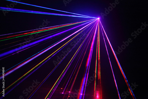 Photo: Lot of beautiful multi-colored laser beams in dark at disco. Lot of beautiful multi-colored laser beams in dark at disco.