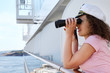 happy woman dressed in cap stands on ship board