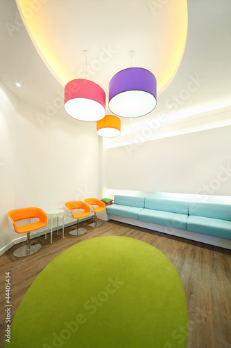 Photo: Empty lit room with bright armchairs, soft couches and lamps. Empty lit room with bright armchairs, soft couches and lamps.