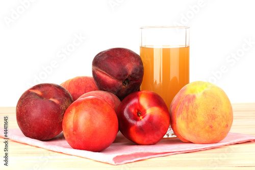 Photo: Ripe peaches and juice on wooden table on white background Ripe peaches and juice on wooden table on white background