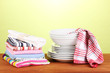 kitchen towels with dishes on green background close-up
