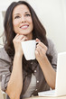 Beautiful Woman Using a Computer and Drinking Tea or Coffee