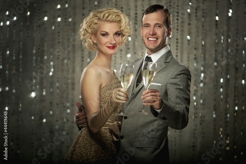 Photo: Retro couple with glasses of champagne Retro couple with glasses of champagne
