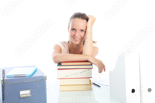 Photo: Smiling female student sitting at her desk relaxing Smiling female student sitting at her desk relaxing