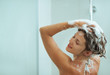 Woman applying shampoo in shower