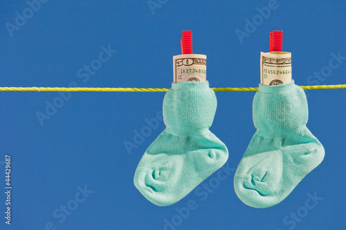 Photo: Baby Socken auf Wäscheleine mit Dollar Geldscheine Baby Socken auf Wäscheleine mit Dollar Geldscheine