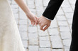 Bride and groom holding hands outdoors