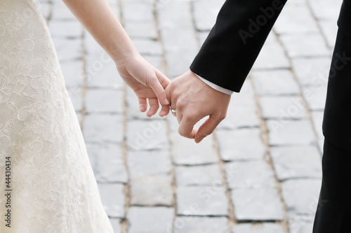 Photo: Bride and groom holding hands outdoors Bride and groom holding hands outdoors