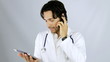 Video: Doctor talking on the phone while looking tablet Doctor talking on the phone while looking tablet
