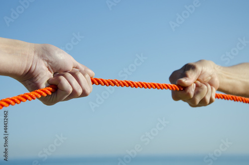 Photo: Hands on rope sky background Hands on rope sky background