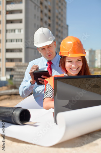 Photo: Two architects works in front of building site Two architects works in front of building site