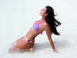 Mujer latina tomando sol en una playa.
