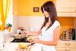 Foto: Beautiful young women preparing food in the kitchen Beautiful young women preparing food in the kitchen