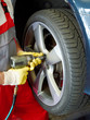 Motor mechanic is changing a tyre with new alu rim