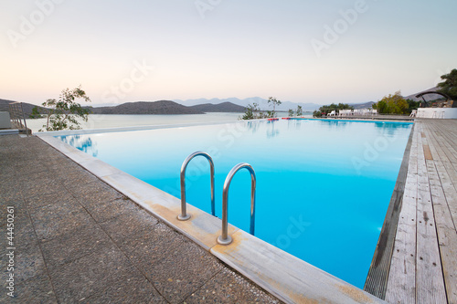 Photo: Blue swimming pool with Mirabello Bay view on Crete, Greece Blue swimming pool with Mirabello Bay view on Crete, Greece