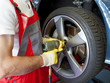 To fit a summer tyre with impact screwdriver on a service lift